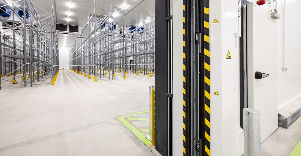 Modernes Tiefkühllager mit Hochregalsystem und Schnelllauftor – effiziente Kühlraumbau-Lösung für Logistik und industrielle Lagerung.